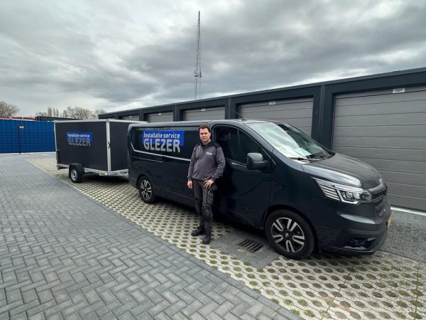 Monteur van Installatie Service Glezer naast bedrijfsbus en aanhanger voor cv-installaties